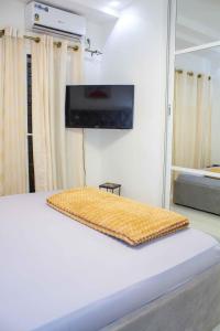 Schlafzimmer mit einem Bett und einem Flachbild-TV an der Wand in der Unterkunft Happyhomes in Dakar