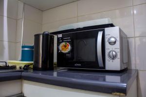 a microwave sitting on top of a counter at Happyhomes in Dakar