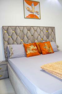 Una cama con almohadas de color naranja y morado. en Happyhomes en Dakar