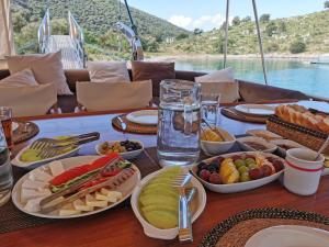 a table with plates of food on a table with water at Hayat Bu, Boot in Fethiye