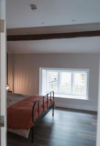 1 dormitorio con cama y ventana en Apartment at 68, en Saintfield