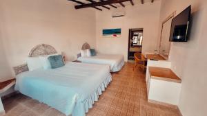 a bedroom with two beds and a television in it at Hotel Margarita Village in Porlamar