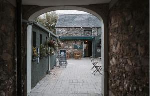 an archway leading to a patio with tables and chairs at Apartment at 68 in Saintfield