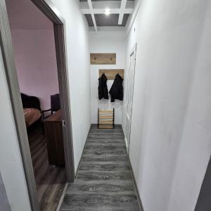 korytarzem prowadzącym do pokoju z białymi ścianami i szafą w obiekcie koberidze w Kutaisi