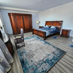 1 dormitorio con 1 cama, 1 silla y 1 alfombra en koberidze, en Kutaisi