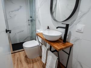a bathroom with a sink and a toilet and a mirror at Sweet Lloret Suites - Smart Hotel in Lloret de Mar +38 photos