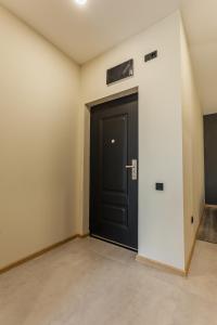 a black door in a room with a wall at Grmagele Apartments in Tbilisi City
