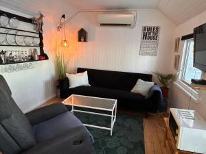 uma sala de estar com um sofá e uma mesa em Strandhytten em Koege