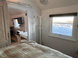 Schlafzimmer mit einem Bett und Meerblick in der Unterkunft Strandhytten in Køge