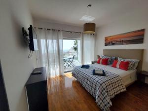 una camera con letto, TV e balcone di "Villa Panoramic View over the Sea"-R ad Albufeira