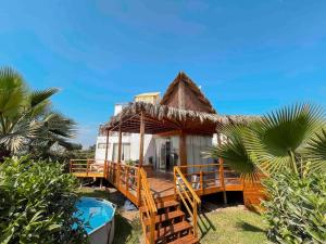 a resort with a deck and a swimming pool at Luhana Chincha® Hermosa Casa de Playa in Casa Blanca