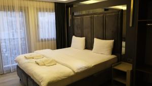 a bedroom with a bed with two towels on it at TALLES CITY HOTEL in Konak
