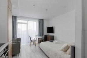 a hotel room with a bed and a table at Ozo eco apartments 5 in Vilnius