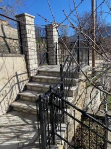 un conjunto de escaleras con una valla negra en Agnes Cottage House, en Konitsa