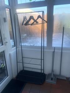 a shelf in a room with a window with hangers at Long Lane Cottage in Broadwell
