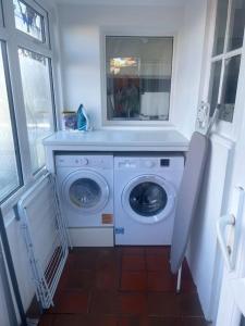 a washing machine in a room with a window at Long Lane Cottage in Broadwell