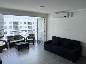 ein Wohnzimmer mit Couch und Balkon in der Unterkunft Aqualina Orange Girardot, décimo piso in Girardot