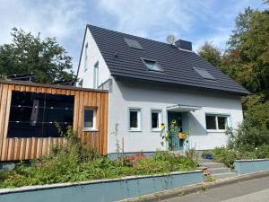 ein weißes Haus mit schwarzem Dach in der Unterkunft Bed & Breakfast am Rheinsteig Bad Honnef in Bad Honnef am Rhein