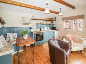 uma cozinha e sala de estar com armários azuis e uma mesa em Westfield Lodge em York