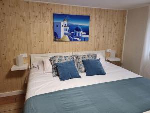 Un dormitorio con una gran cama blanca con almohadas azules. en Apartamento El Olivo, en Vigo