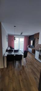 uma sala de estar com uma mesa de jantar e cadeiras em Apartament Zielone Ogrody em Stargard