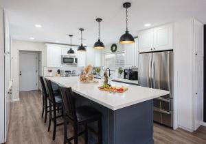 a kitchen with a large white island with bar chairs at Scottsdale - 6839 E Kelton Lane in Scottsdale
