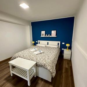 een slaapkamer met een bed met een blauwe muur bij Lalla Home in Bari