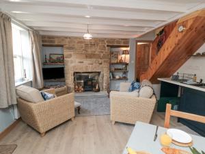 a living room with two chairs and a fireplace at Rose Lea in Saltburn-by-the-Sea