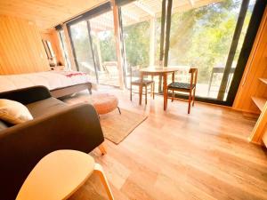 a living room with a bed and a table and chairs at Espectacular Loft en Lago Chapo M4 in Puerto Montt
