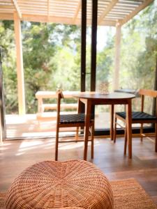a table and chairs in a room with a porch at Espectacular Loft en Lago Chapo M4 in Puerto Montt
