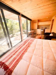 a large bed in a room with a large window at Hermoso Loft en Lago Chapo con Hot Tub M1 in Puerto Montt