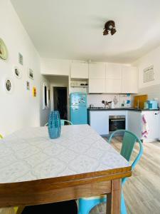 a kitchen with a table and a blue refrigerator at MALU Bilo CON GIARDINO WIFI E POSTO AUTO IN CENTRO A SIROLO in Sirolo