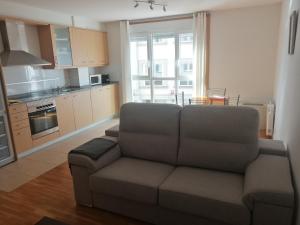 a living room with a couch and a kitchen at Apartamentos MonteBlanco Costa da Morte in Neaño