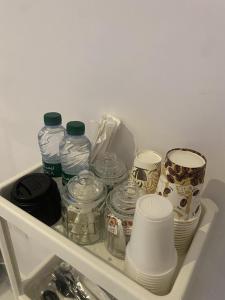 una estantería en una nevera llena de platos y botellas de agua en Singles Room en Yeda
