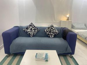 Sofá azul en la sala de estar con mesa en Singles Room en Yeda
