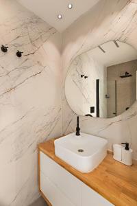 een badkamer met een witte wastafel en een spiegel bij וילת נופש בוטיק in Zanoaẖ
