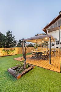 een houten terras met een picknicktafel en een parasol bij וילת נופש בוטיק in Zanoaẖ