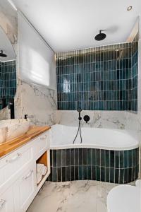 een badkamer met een bad en een wastafel bij וילת נופש בוטיק in Zanoaẖ