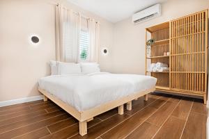 een slaapkamer met een groot bed met witte lakens bij וילת נופש בוטיק in Zanoaẖ