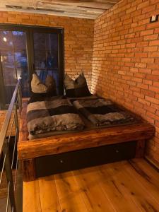 a bed in a room with a brick wall at Ferienwohnung Loft Schwielowsee mit Sauna in Schwielowsee