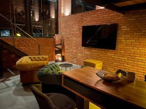 a living room with a wooden table and a brick wall at Ferienwohnung Loft Schwielowsee mit Sauna in Schwielowsee