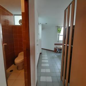 a small bathroom with a toilet and a hallway at Hepico Departamentos Piura in Piura