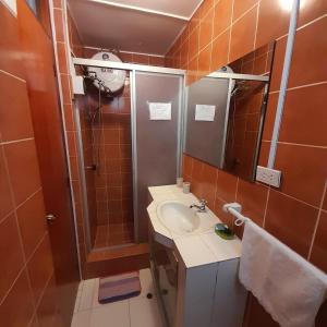 a small bathroom with a sink and a shower at Hepico Departamentos Piura in Piura