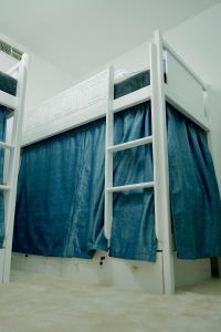 two bunk beds in a room with blue curtains at Curve Hostel JBR in Dubai