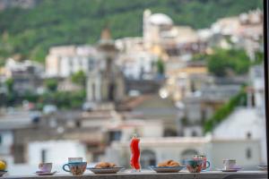 a table with plates of food and a view of a city at Casa Donna Cunce in Positano