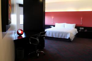ein Hotelzimmer mit einem Bett und einer roten Wand in der Unterkunft Holiday Inn Mexico Dali Airport, an IHG Hotel in Mexiko-Stadt