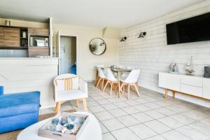 ein Wohnzimmer mit Tisch und Stühlen in der Unterkunft Les Maisons de Belle Dune - maeva Home - Maison 4 pièces 6 personnes Prestige MAE-2648 in Fort-Mahon-Plage