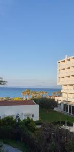 a white building with the ocean in the background at RELAXING SUMMER HOUSE HANIOTI in Hanioti
