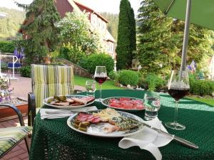 Pension Rheingold Garni في باد غروند: طاولة مع طبقين من الطعام وكؤوس من النبيذ