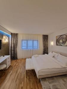 1 dormitorio con 1 cama blanca grande y escritorio en Rokebea Luxury en Brasov